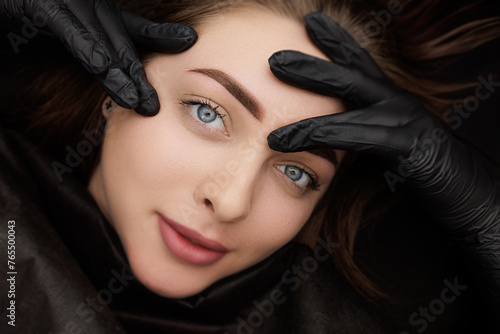 Beautiful girl poses in front of the camera after permanent eyebrow makeup. Second PMU procedure in a month of permanent eyebrow makeup. Permanent makeup correction.