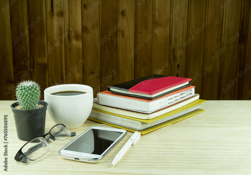 Naklejka premium Office desk table with notebooks,glasses, smart phone and a cactus