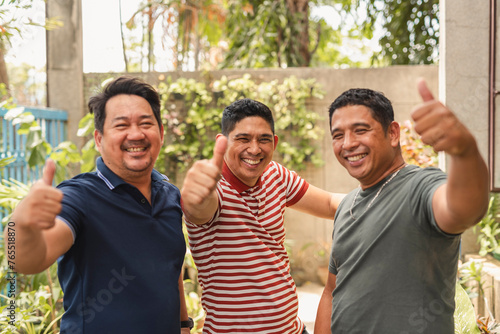 Three asian men in their forties smiling and giving a thumbs up together