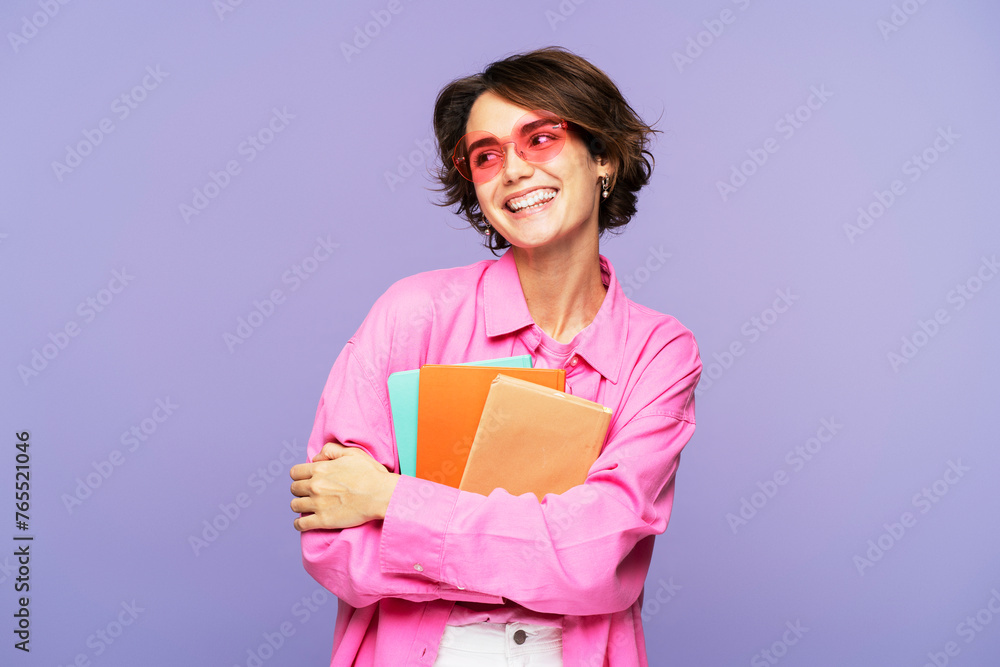 Adorable glamorous woman wearing sunglasses, holding books and hugging them Adorable glamorous woman wearing sunglasses, holding books and hugging them