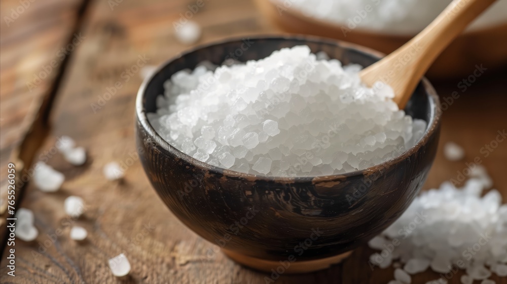 Close-up of sea salt in a wooden bowl on a rustic table Close-up of sea salt in a wooden bowl on a rustic table