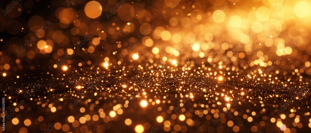  A sharp image of glittering gold dust on a dark background surrounded by soft, fuzzy lights in the foreground