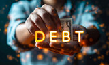 A person holds a bag with a dollar sign, representing the burden and concept of debt, while the word DEBT is displayed prominently, symbolizing the financial obligations and challenges many face