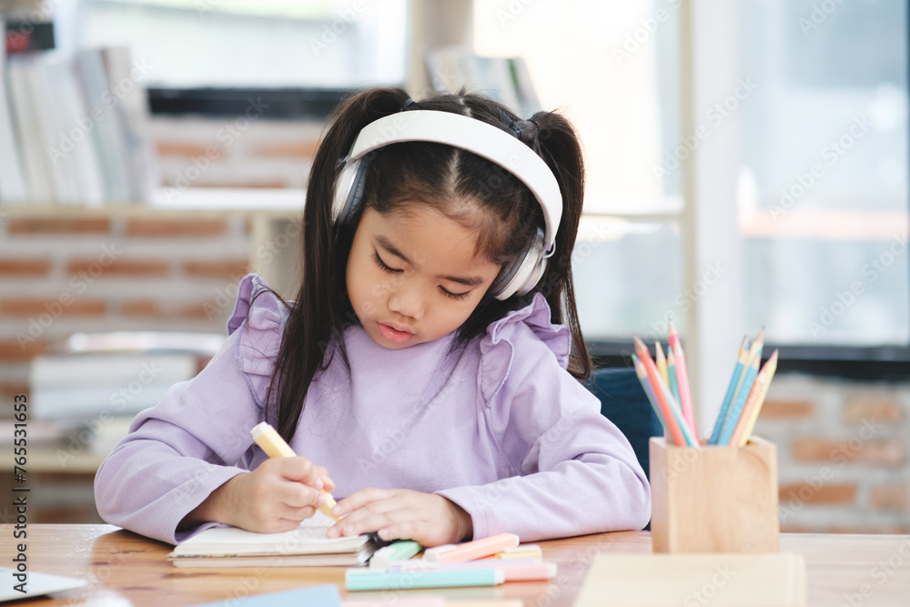 A young girl is sitting at a desk with a pencil and a notebook A young girl is sitting at a desk with a pencil and a notebook