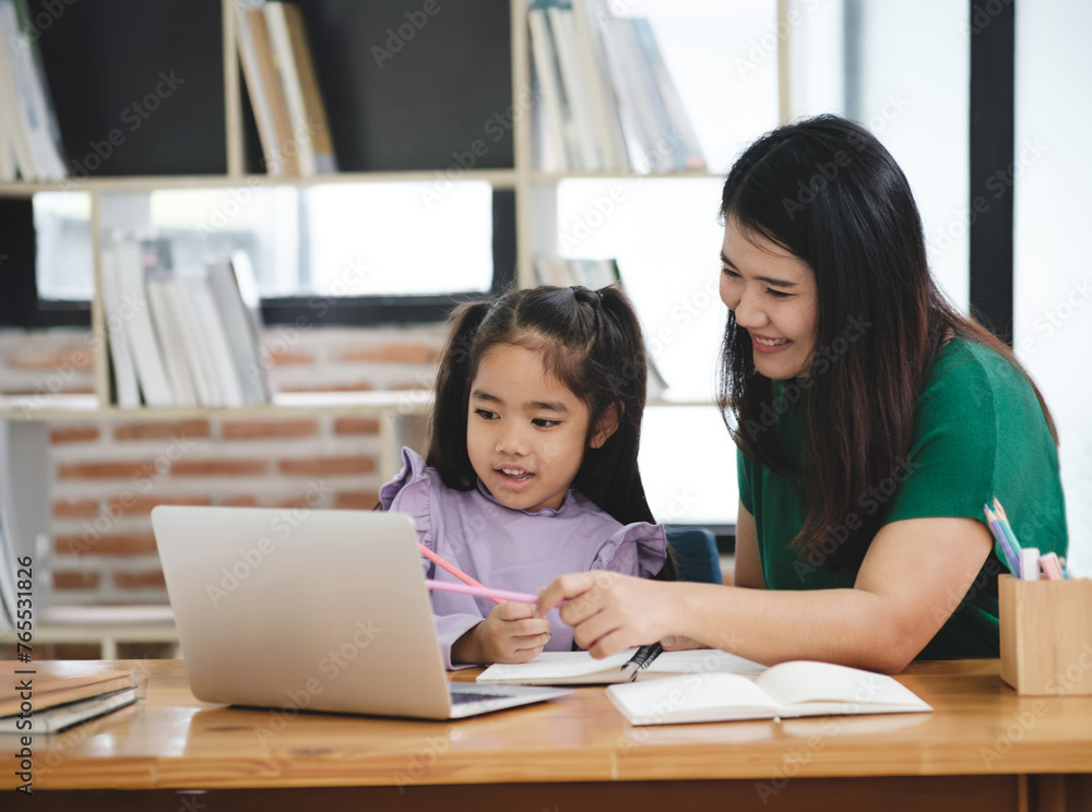A woman is helping a young girl with her homework A woman is helping a young girl with her homework