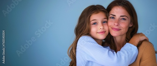 horizontal portrait of daughter hugging her mother, solid color background, mother's day