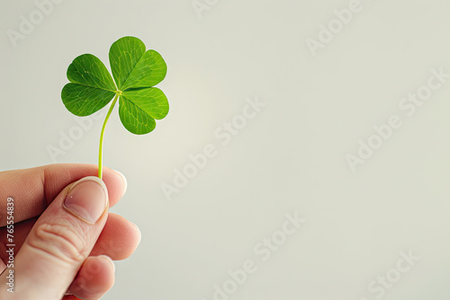 A hand holding a st patricks day lucky irish four leaf clover © Sattawat