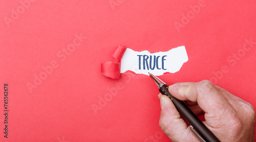 Truce, word written on ripped paper background