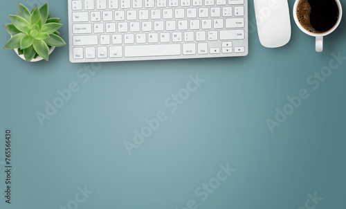 Office desk with stationary,keyboard,notebook,calculator,pencil,coffee and flower on blue table