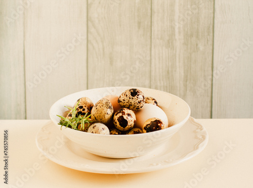 Rustic Easter still life of beautiful quail's and chicken eggs over white table