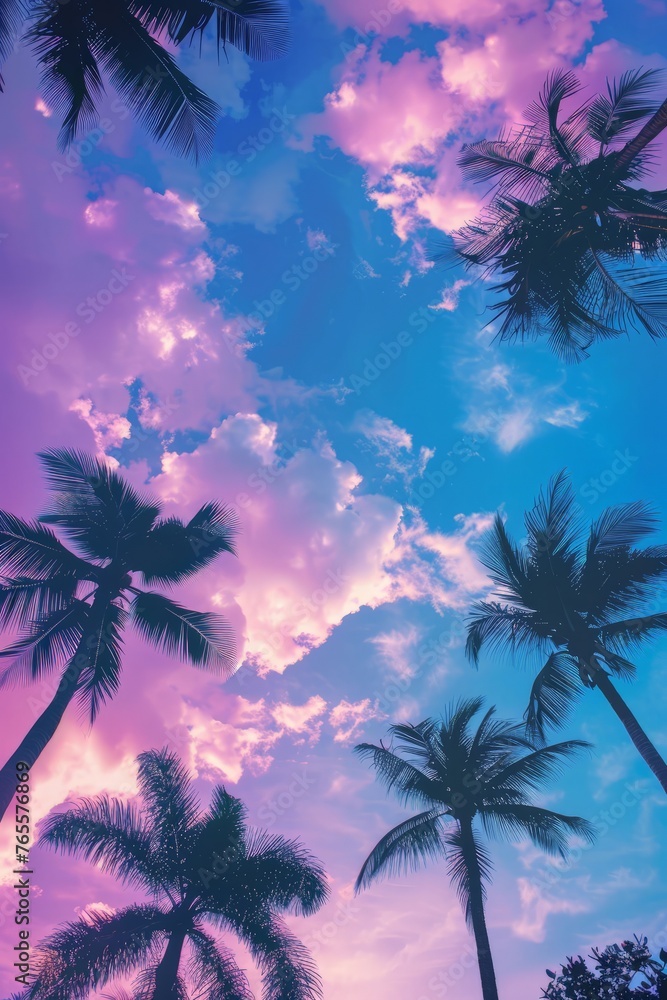 Palm trees are dark silhouettes against a vibrant purple and blue sky, creating a striking contrast in the tropical landscape