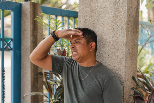 Stressed Asian man facing financial difficulties with mounting bills photo