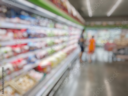 Blurred supermarket, grocery with customers shopping, bokeh light background. © nilawan