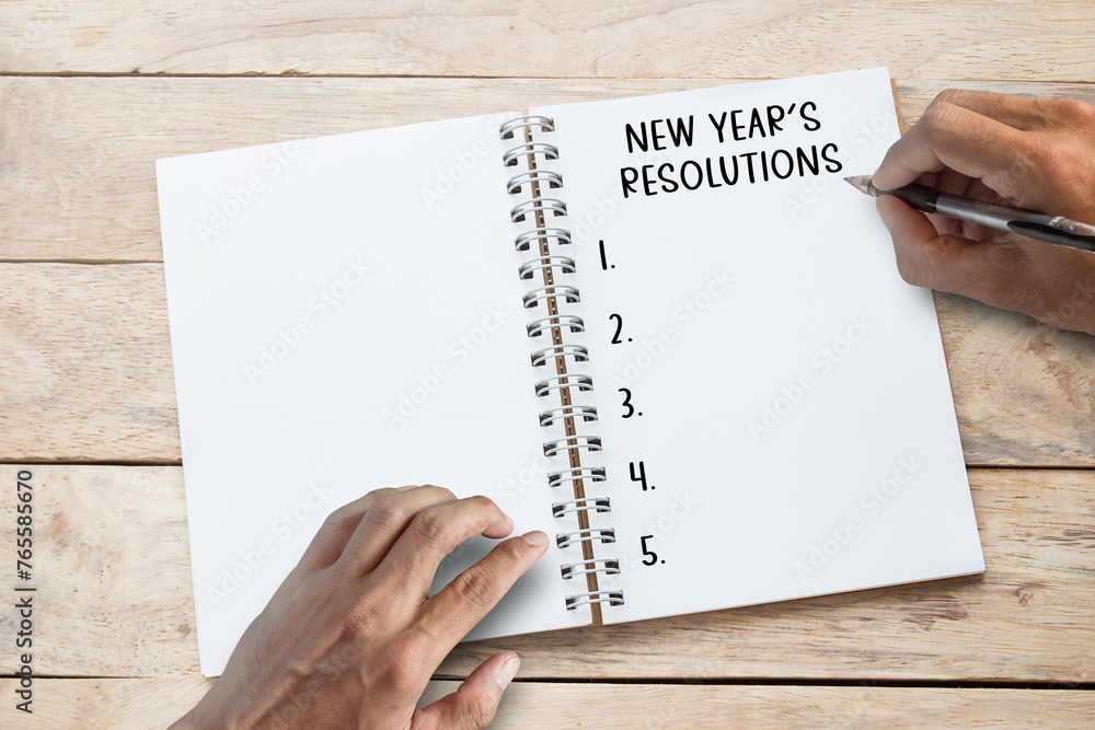 NEW YEAR'S RESOLUTIONS.Text on notebook on office desk workplace NEW YEAR'S RESOLUTIONS.Text on notebook on office desk workplace