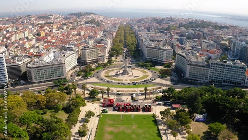 Aerial Tilt Up Shot Of Famous Marquis Of Pombal Square Roundabout Amidst Residential Buildings On City Landscape - Lisbon, Portugal photo