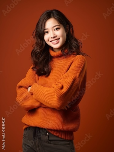 Woman in Orange Sweater Poses for Picture