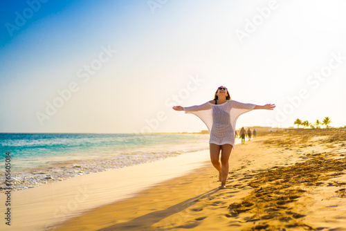 Beautiful woman walking on sunny beach 