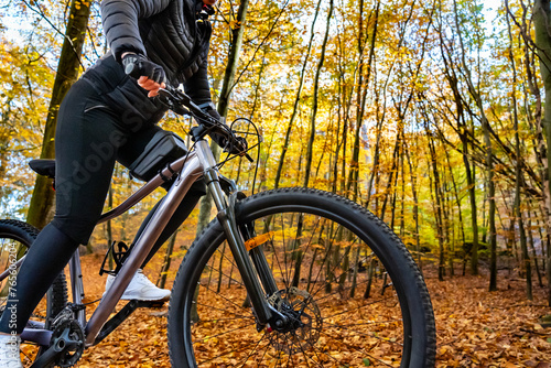 Woman riding bicycle in city forest in autumn scenery  © Jacek Chabraszewski