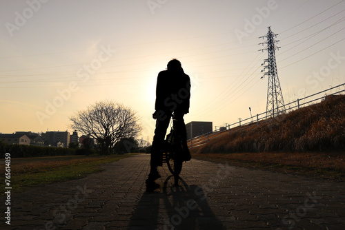 Silhouette man riding a bycicle with beautiful sunset