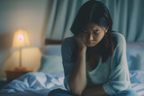 Asian girl feeling sad and lonely in the bedroom under dim light