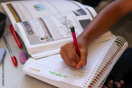 Estudante fazendo anotações no caderno na sala de aula.  photo