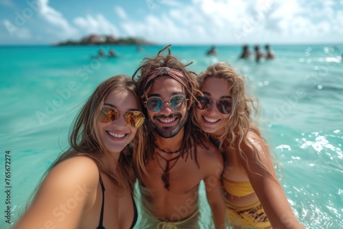 Group of three happy friends taking a selfie in crystal clear tropical waters, smiling broadly