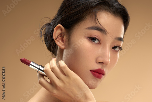 Young and beautiful women apply makeup and lipstick