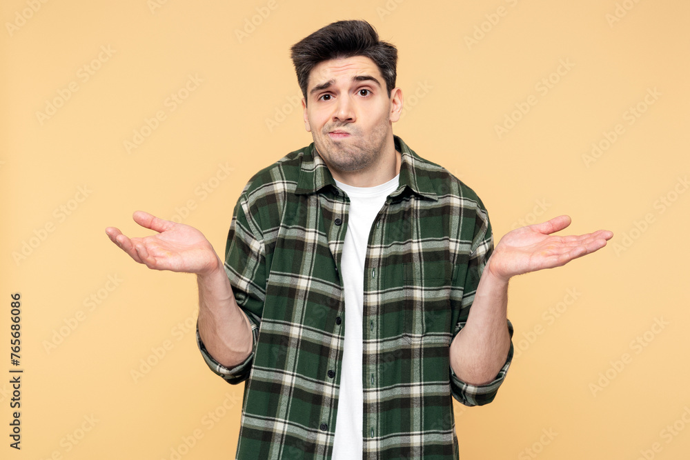 Upset man making a hand gesture, showing doubt through facial expression, isolated yellow background Upset man making a hand gesture, showing doubt through facial expression, isolated yellow background