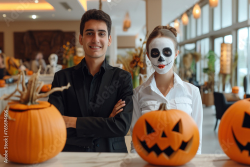 Smiling Young Man and Woman with Skull Makeup by Halloween Pumpkins