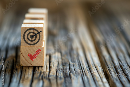 Wooden blocks with a target and a check mark. The concept of achieving goals, tasks, and objectives. photo