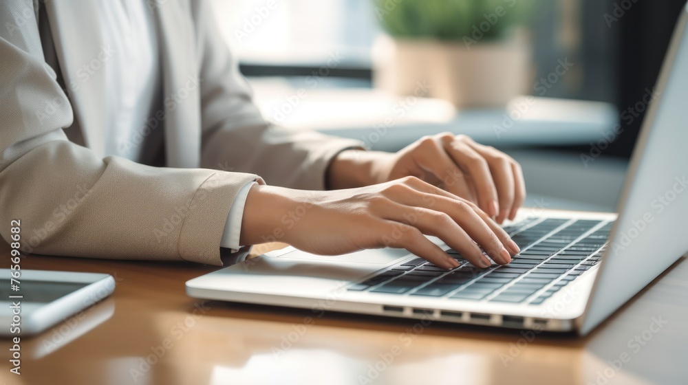 Close up of female hands typing on laptop keyboard at table or desk in the office, Businessman working in front of laptop on table,Work online or do business online in front of your laptop.