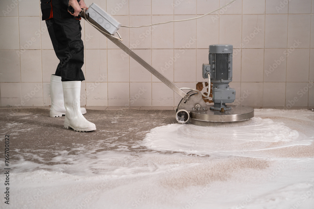 Fototapeta premium Worker cleaning vacuum cleaner carpets, washing carpet with disk machine in laundry
