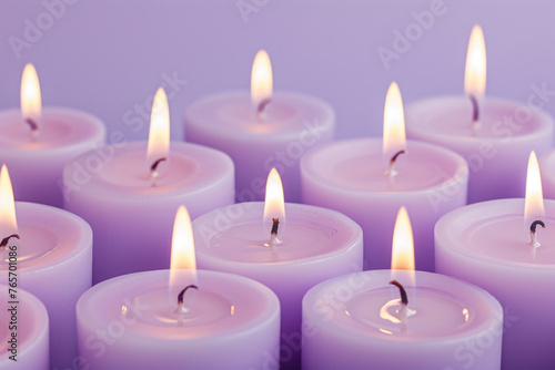 Row of lit candles on purple background with copy space for text