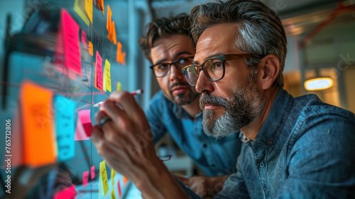 Business Team Brainstorming Marketing Strategy with Sticky Notes on Glass Wall during Meeting