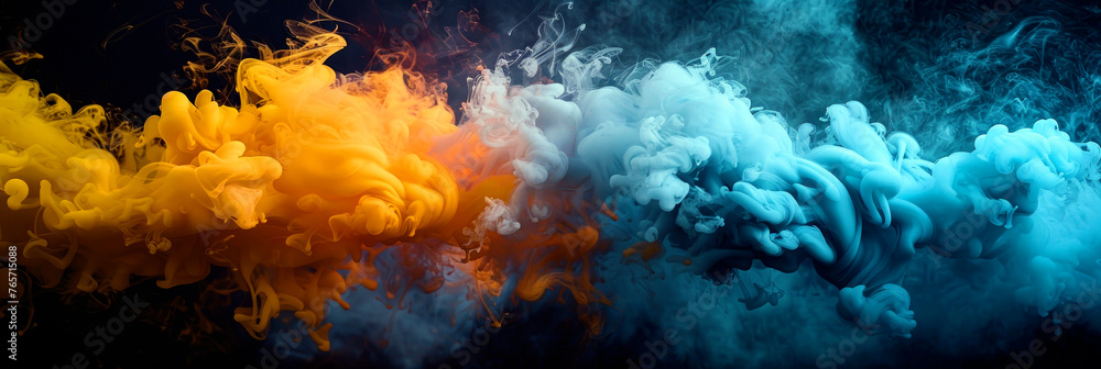 Colorful blue and yellow smoke merging and swirling while flowing on black background.