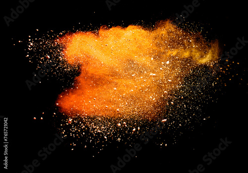 Abstract powder splatted background. orange powder explosion on black background. Colored cloud. Colorful dust explode. Paint Holi