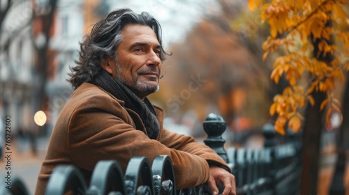 Smiling Senior Man Leaning On Wooden Fence On Walk Through Autumn Park Or Countryside © PaulShlykov
