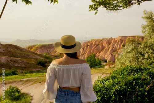 beautiful woman in a white hat looking to the view of cappadocia, turkey