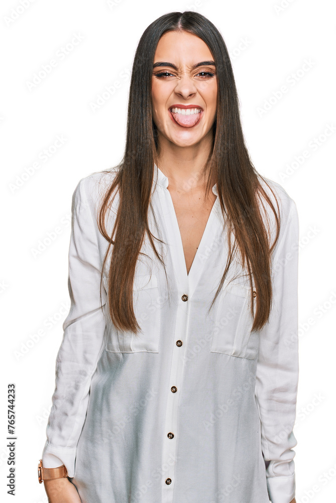 Young beautiful woman wearing casual white shirt sticking tongue out happy with funny expression. emotion concept. Young beautiful woman wearing casual white shirt sticking tongue out happy with funny expression. emotion concept.