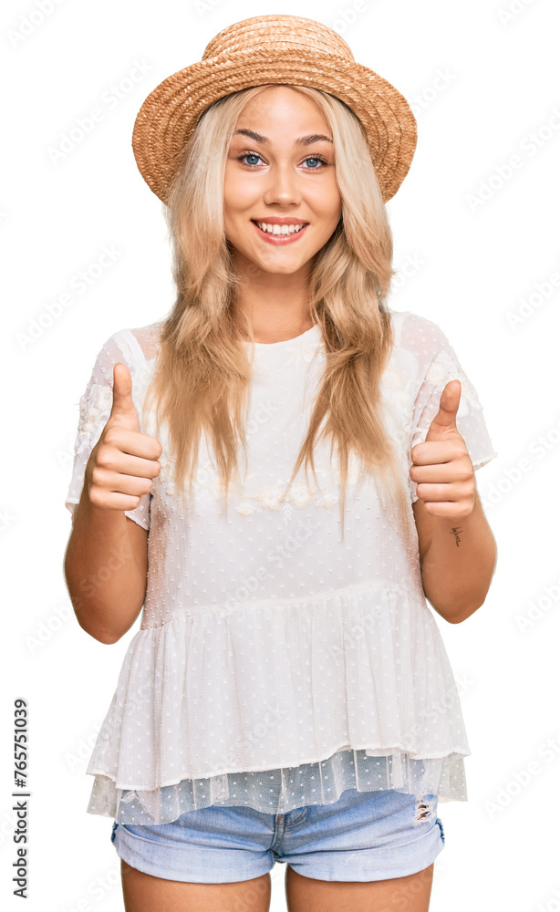 Young blonde girl wearing summer hat success sign doing positive gesture with hand, thumbs up smiling and happy. cheerful expression and winner gesture. Young blonde girl wearing summer hat success sign doing positive gesture with hand, thumbs up smiling and happy. cheerful expression and winner gesture.