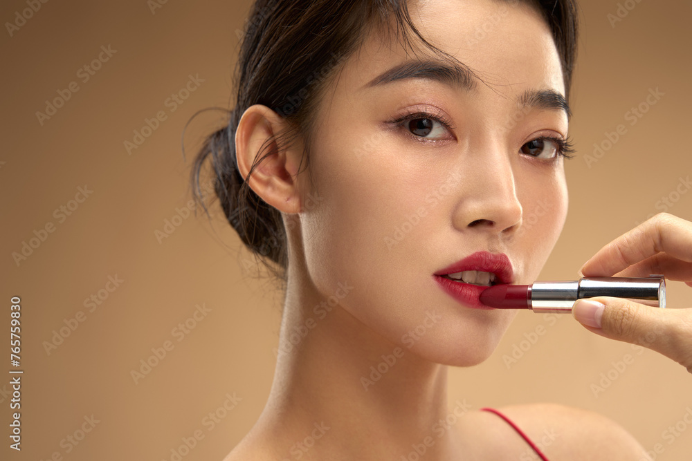 Young and beautiful women apply makeup and lipstick Young and beautiful women apply makeup and lipstick
