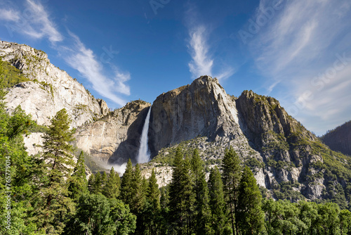 Yosemite National Park...Granite rocks and a pine forest frame Upper Yosemite Fall in a thunderous drop. Taken from Yosemite Valley in June 2023 when record snow resulted in peak water flow. photo