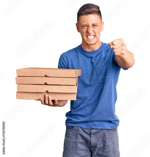 Young handsome hispanic man holding delivery pizza box annoyed and frustrated shouting with anger, yelling crazy with anger and hand raised