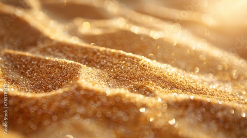 Macro shot of golden beach sand shimmering in sunlight, capturing the sparkling texture and warm tones of a sunny day at the beach.