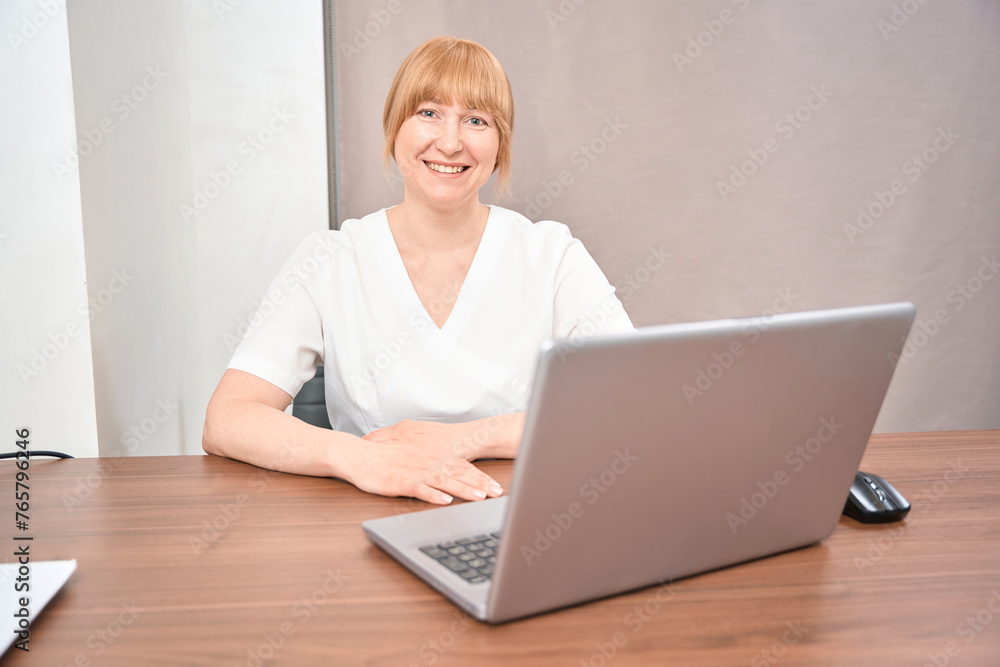 Smiling woman therapist keeping medical appointment of citizens in office Smiling woman therapist keeping medical appointment of citizens in office