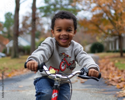 Smiling young boy enjoying a bike ride in an autumnal neighborhood, embodying childhood joy and freedom.