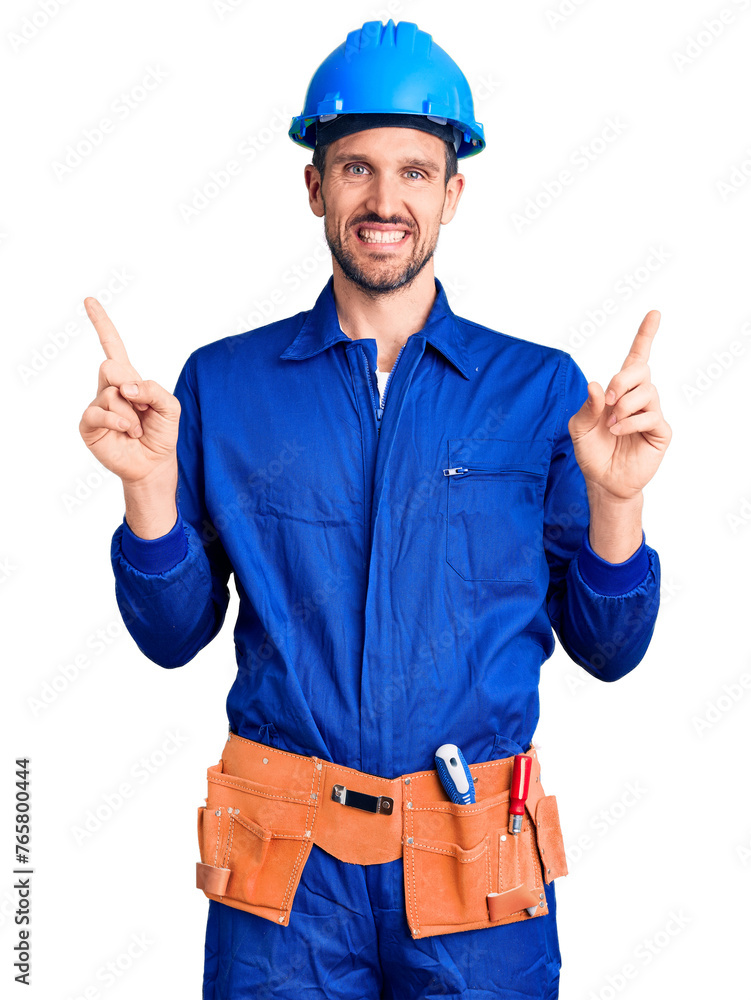 Young handsome man wearing worker uniform and hardhat smiling confident pointing with fingers to different directions. copy space for advertisement