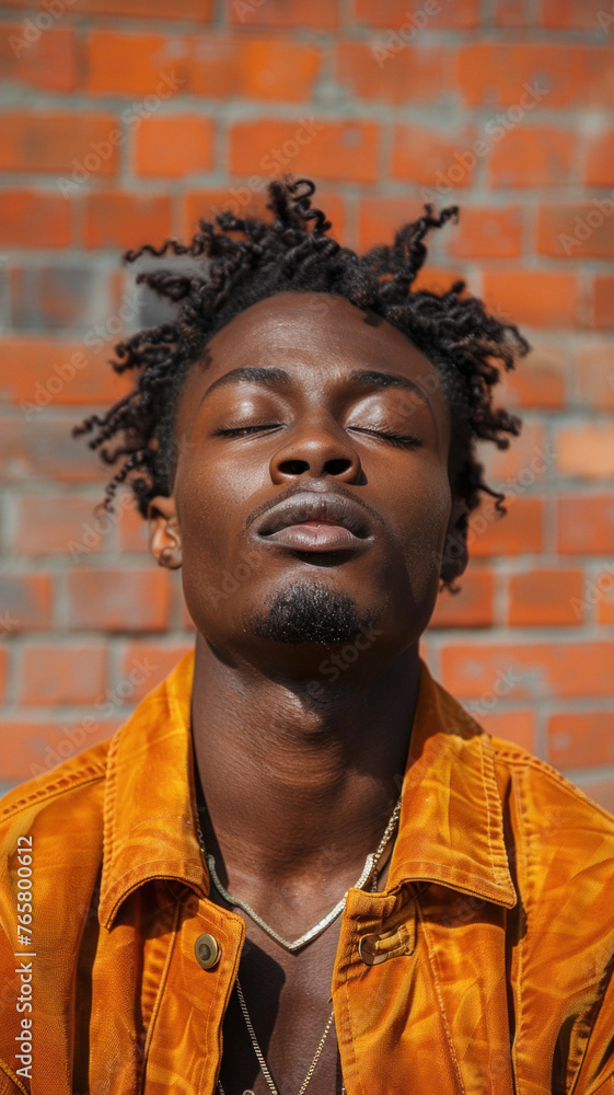 Portrait of African attractive man against background of red brick wall Portrait of African attractive man against background of red brick wall