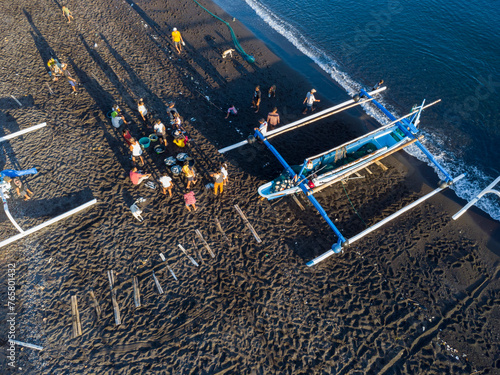 Fischer laden am Morgen, am schwarzen Strand von Amed, Fische aus ihren Auslegerboote, Berg Agung im Hintergrund, Amed Bali, Indonesien