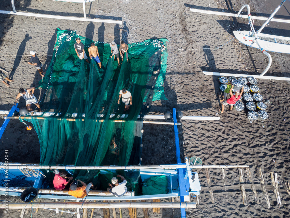 Fischer laden am Morgen, am schwarzen Strand von Amed, Fische aus ihren Auslegerboote und legen die Netze zusammen, Berg Agung im Hintergrund, Amed, Karangasem, Bali, Indonesien - obrazy, fototapety, plakaty 